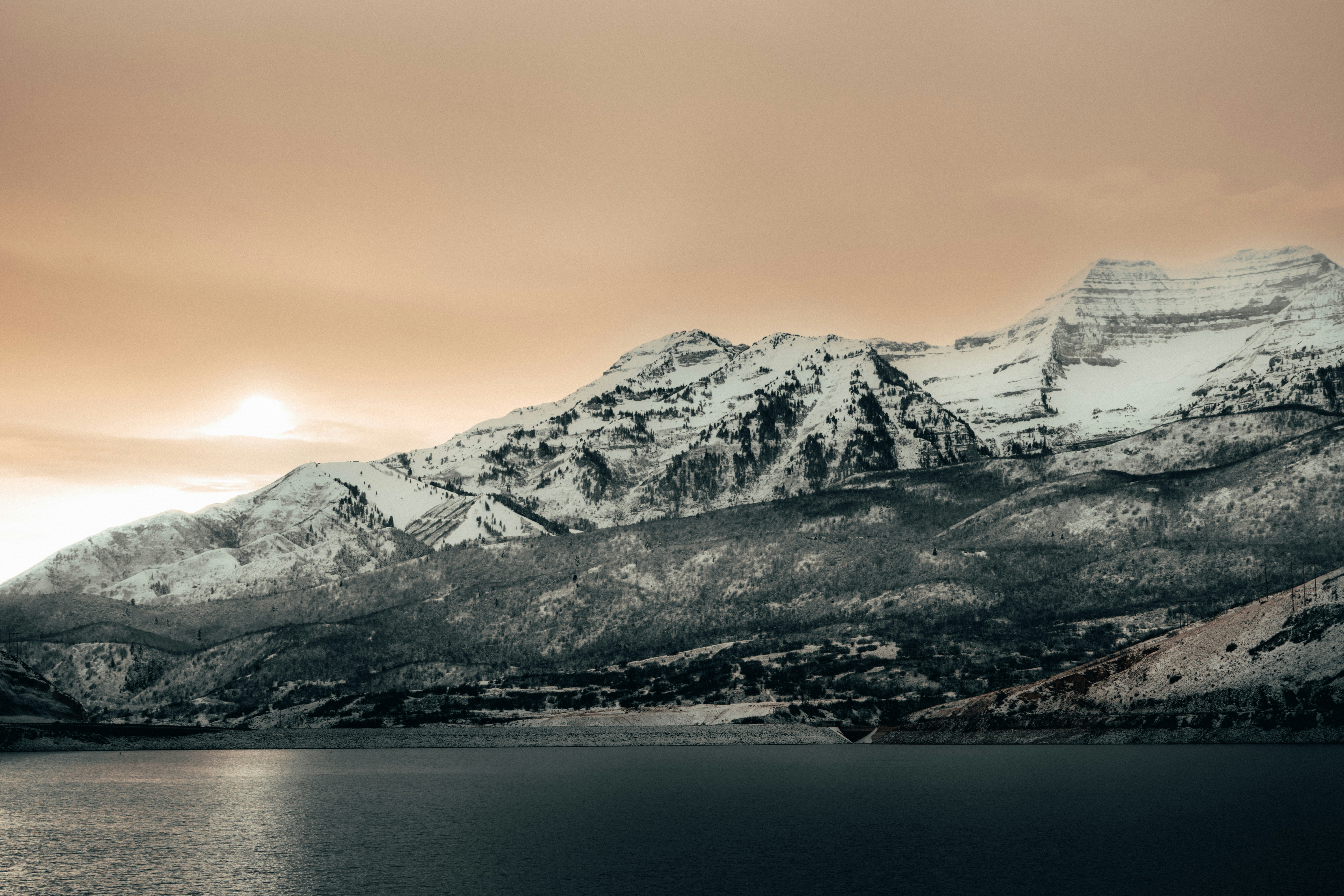 Serene winter landscape with snow-capped mountains reflected in a calm lake, Utah